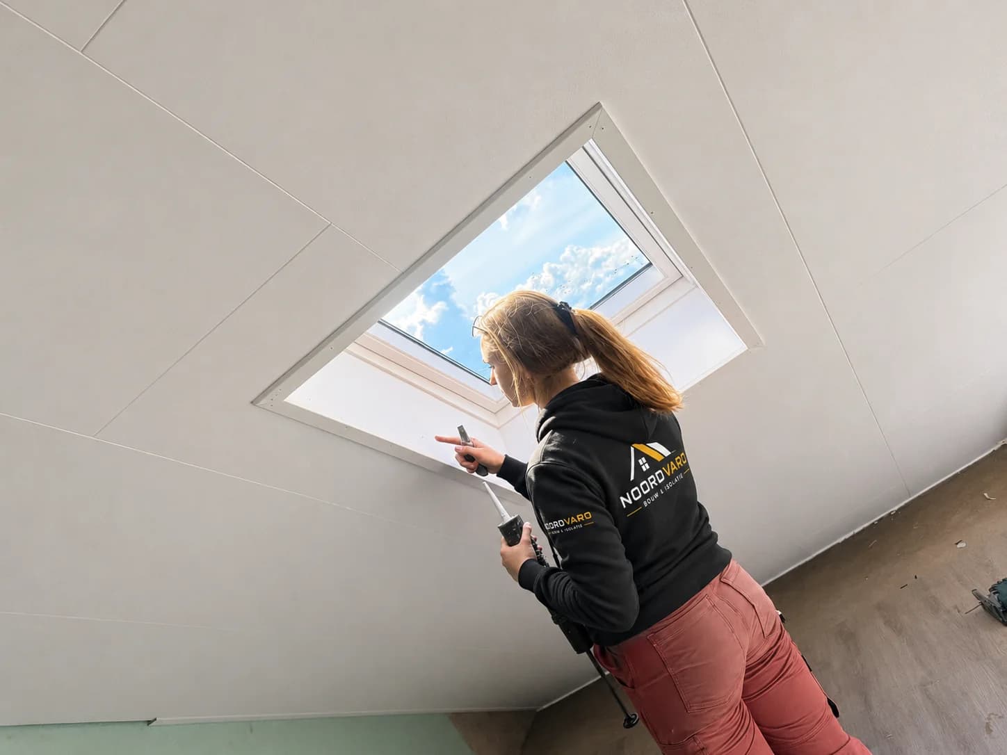 A Noordvaro team member seals the interior connection around a roof window